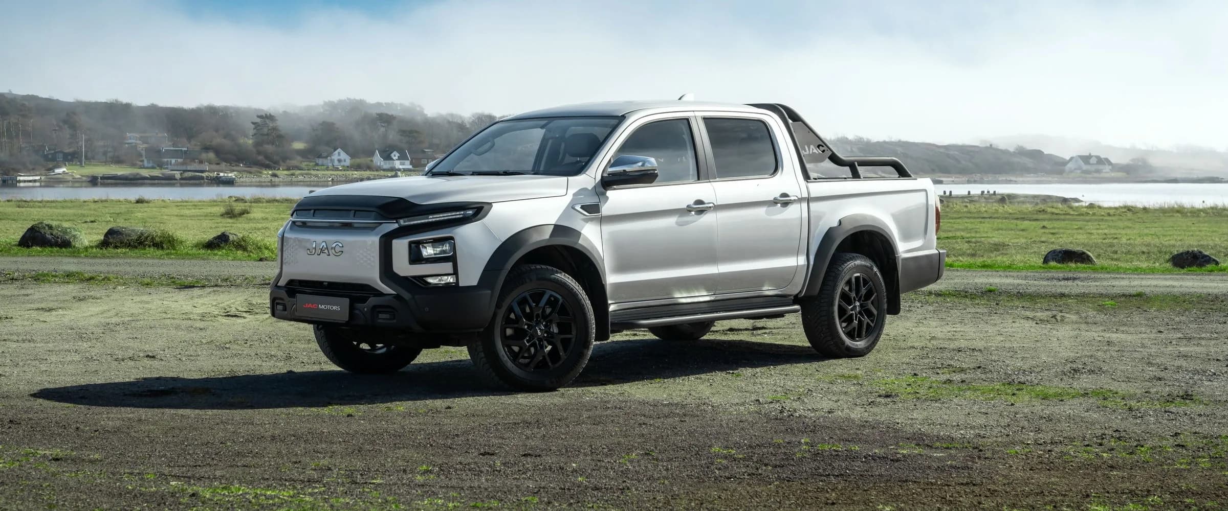 Sølvfarget JAC T9 EV 4x4 på kystlandskap